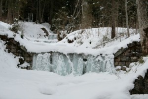 Gefrorener Wasserfall am Rand des Weges