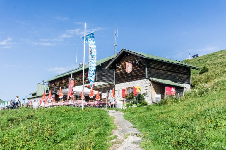 Die Alpenvereinshütte Brauneckhaus liegt nmittelbar neben der Bergstation und dem Gipfelkreuz