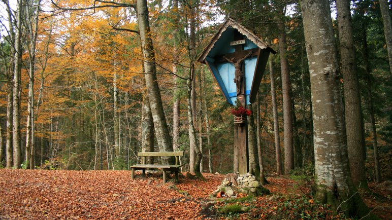 Das Wegkreuz im Wald mit erster Rastmöglichkeit