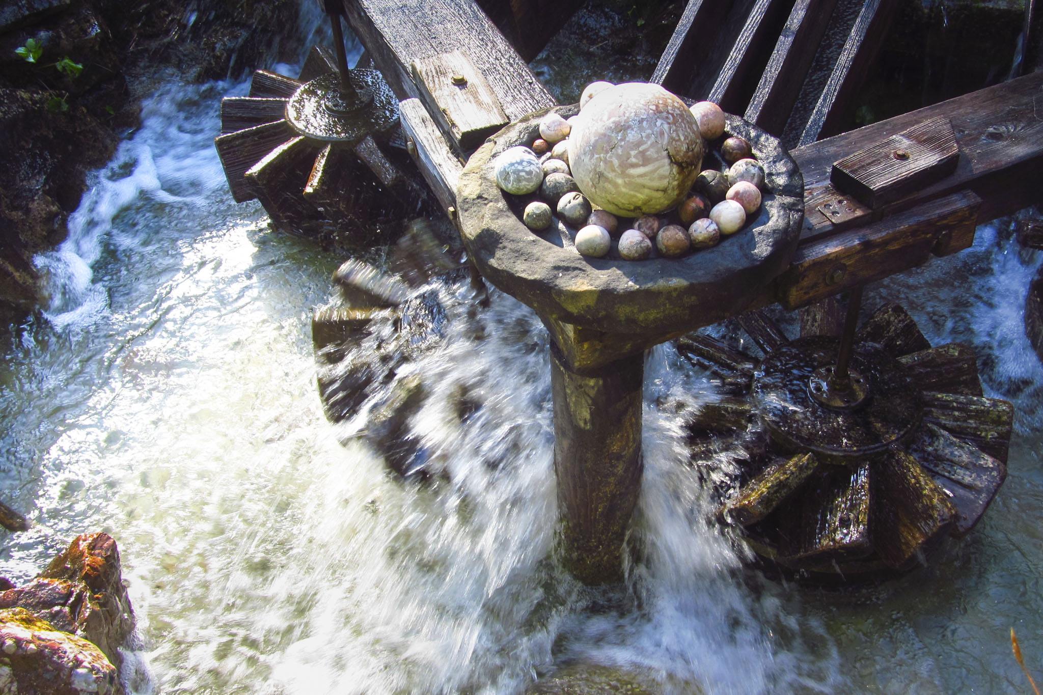 Die Kugelmühle in Aktion. Die Kugeln oben sind nur Dekoration, in den unteren Wasserrädern rotieren die Kugeln Die Kugelmühle in Aktion. Die Kugeln oben sind nur Dekoration, in den unteren Wasserrädern rotieren die Kugeln