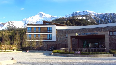 Das Hotel vor den noch verschneiten Bergen Das Hotel vor den noch verschneiten Bergen