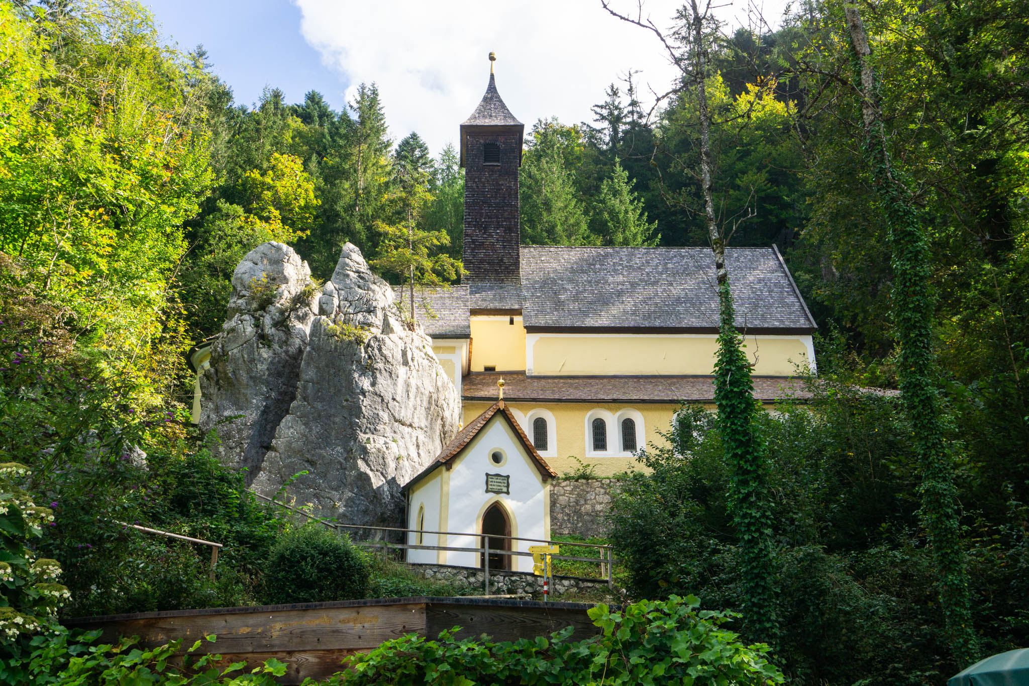 Die Wallfahrtskirche Maria Klobenstein, davor der gespaltene Felsen