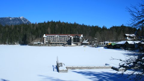 Das Eibsee-Hotel mit dem zugefrorenen See im Vordergrund