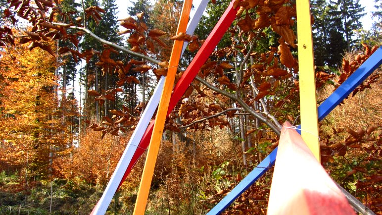 Farbige Stangen und buntes Herbstlaub auf dem Skulpturenweg St. Hubertus