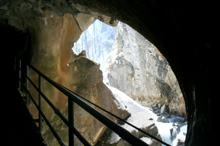 Ein Tunnelfenster am Ende des Klammwegs erlaubt den Blick auf die sonnendurchflutete Partnach