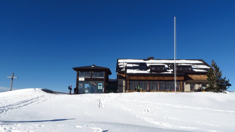 Die Hochrieshütte, direkt neben dem Gipfelkreuz