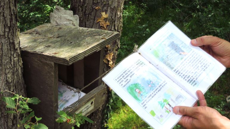 Mehrere Kästen der Grundschule Vezzano stehen am Rand des Weges. Die Schüler haben die Hefte gestaltet.