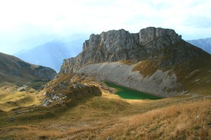 Die wild gezackte Lackenspitze, davor der sehr grüne Grubasee
