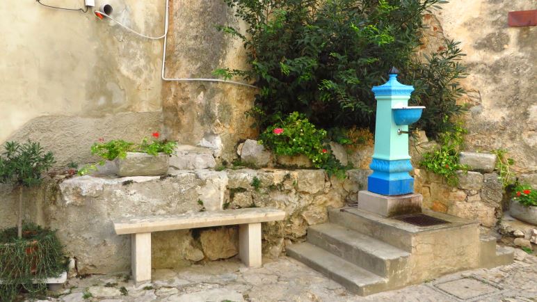 Der bunte Brunnen vor der Kirche ist das Wahrzeichen von Mošćenice