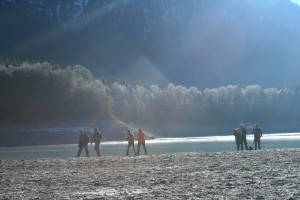 Wanderer an der Wasserkante im Gegenlicht