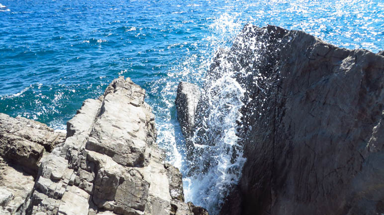 Die Gischt spritzt zwischen den Felsen hoch