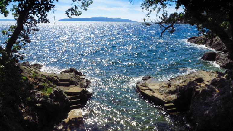 Eine kleine Felsbucht, im Hintergrund liegt die Insel Cres