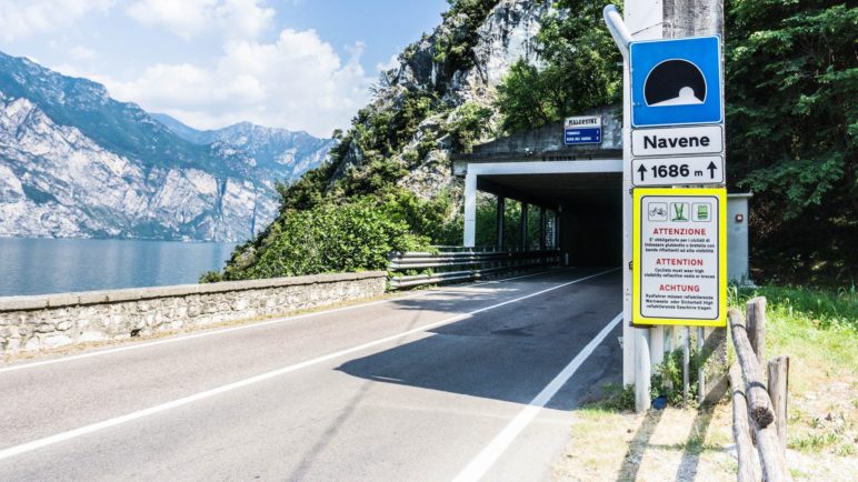 Hiweisschild auf die Warnwestenpflicht am Tunnelportal Navene, von Malcesine in Richtung Torbole