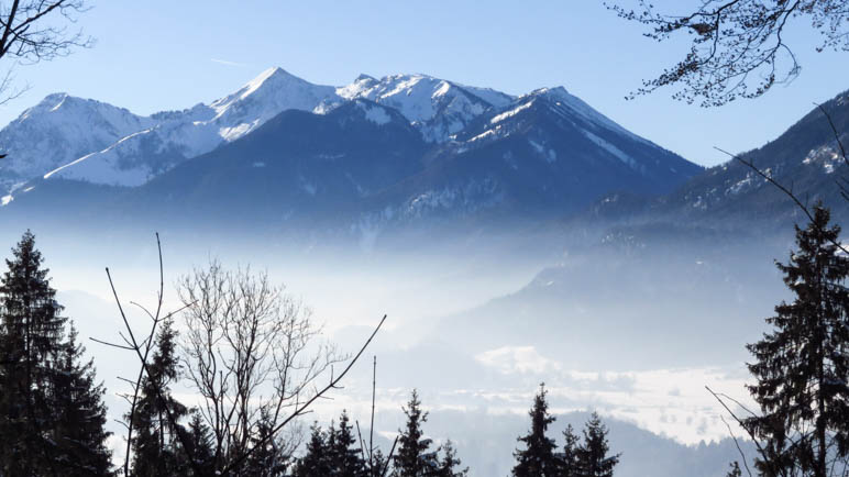 Das Tal liegt im leichten Nebel, darüber die Chiemgauer Berge