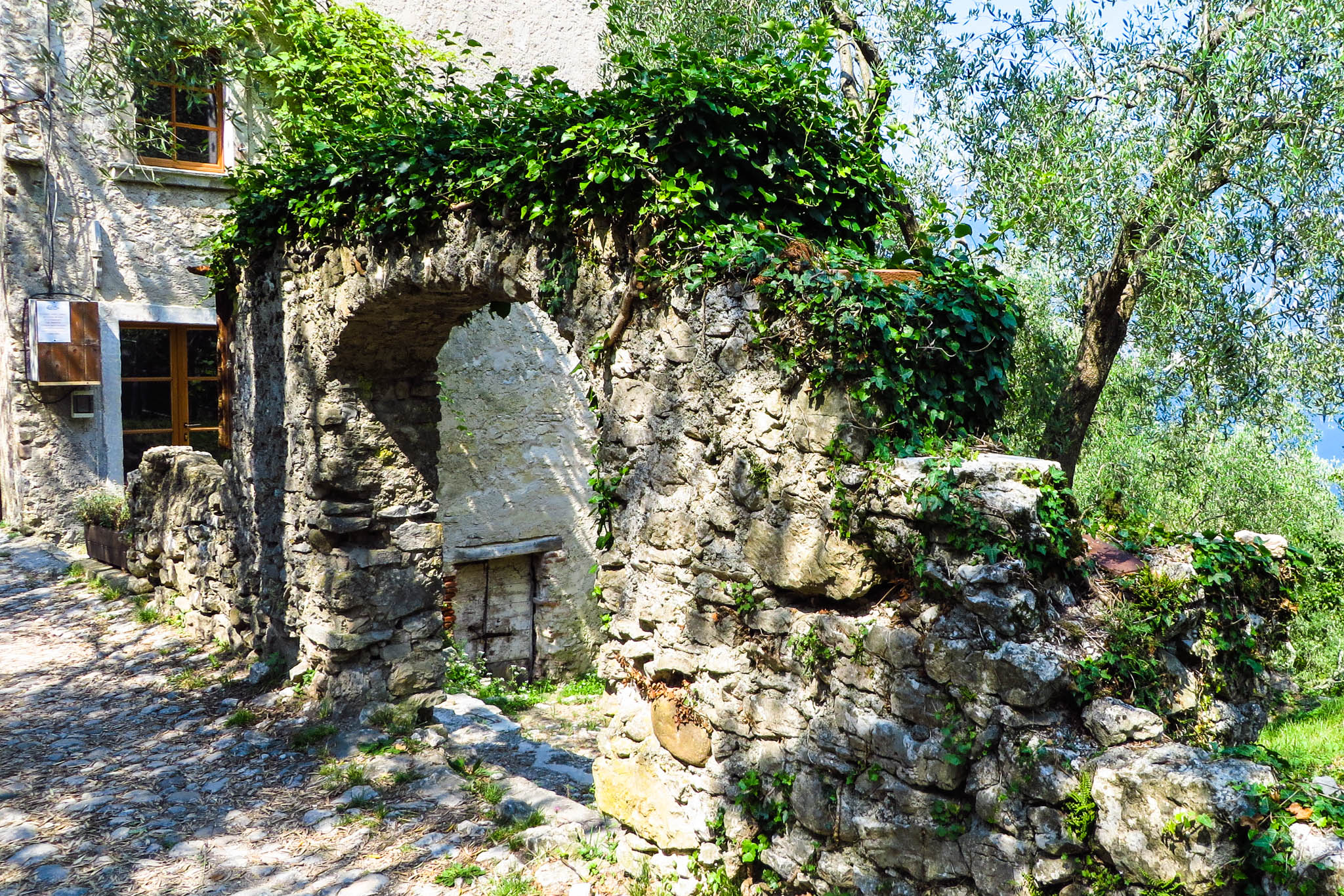 Ein Mauerfragment mit einem Torbogen im Dorf Campo di Brenzone