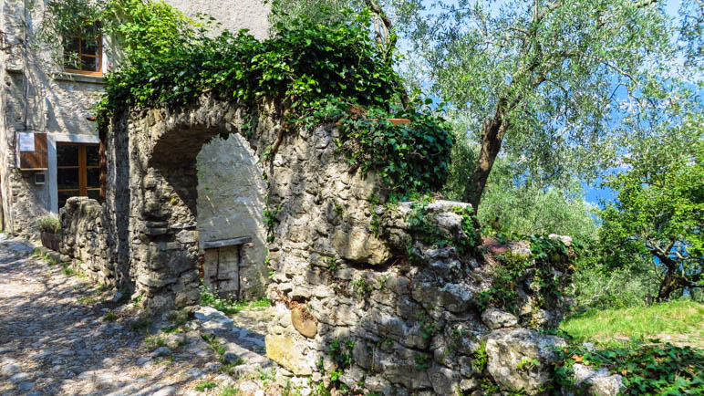 Ein Mauerfragment mit einem Torbogen im Dorf Campo di Brenzone