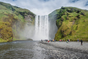 Der Skógafoss zwischen den grünen Felswänden