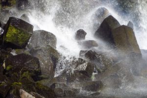 Das Wasser des Svartifoss spritzt über die sechseckigen Basaltsteine