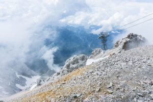 Ehrwald im Tal liegt in den Wolken. Der Stützpfeiler gehört zur Tiroler Zugspitzbahn