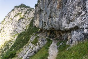 Der Weg führt unter einem Felsüberhang entlang