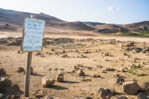 Ein Schild erklärt, warum man auf den Wegen bleiben soll