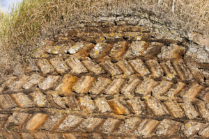 Eine Mauer aus geschichteten Torfziegeln