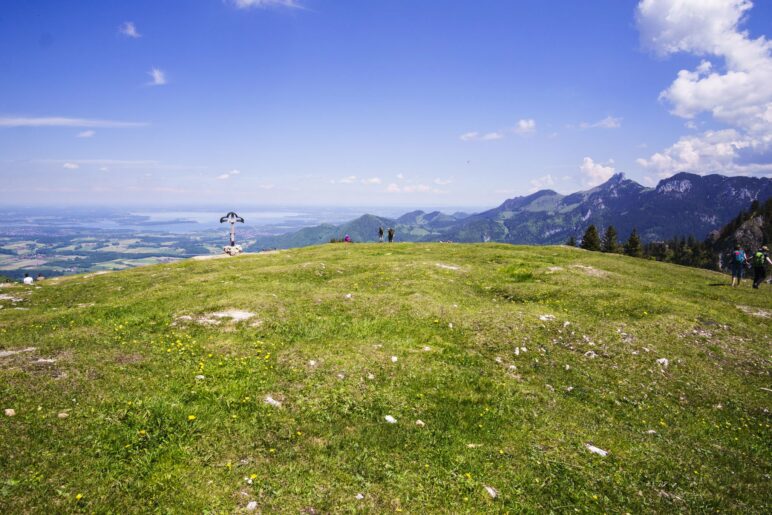 Gleich hinter dem Gipfelkreuz liegt der  Chiemsee, rechts die Kampenwand