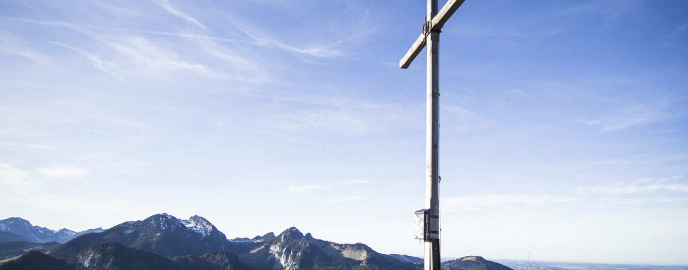 Das Gipfelkreuz auf dem 1337 Meter hohen Großen Riesenkopf. Im Hintergrund liegt der Wendelstein