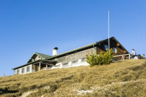 Das Wankhaus, eine Alpenvereinshütte, steht direkt neben dem Gipfelkreuz