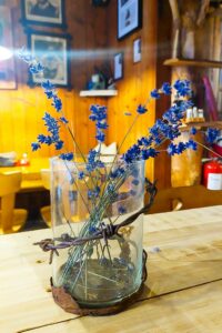 Eine Blumenvase im Gastraum der Hütte. Mit Stacheldraht aus dem Ersten Weltkrieg