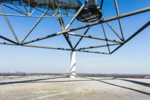 Eine der vier Säulen, auf denen der Tetraeder steht und ein Windrad auf derNachbarhalde