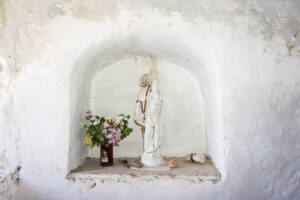 Eine kleine Heiligenfigur in einer Wandnische