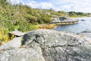 Der Weg am Ufer entlang verläuft neben und auf den Felsen