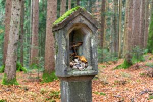 Eine steinerne Stele mit improvisiertem Inhalt steht auch am Weg