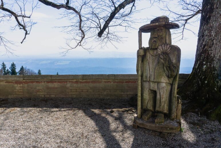 Ein hölzerer Pilger vor der Wallfahrtskirche